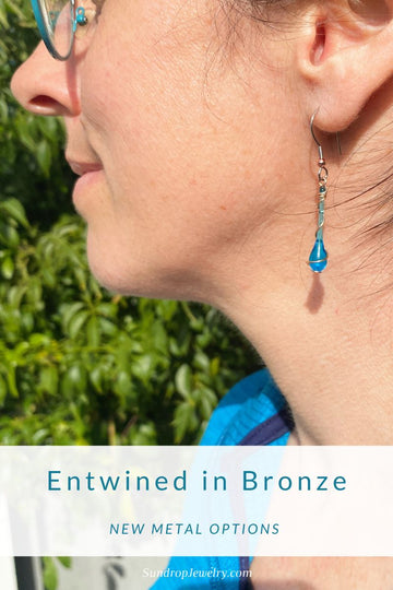 Glass teardrop earrings with a tendril of bronze entwining each drop